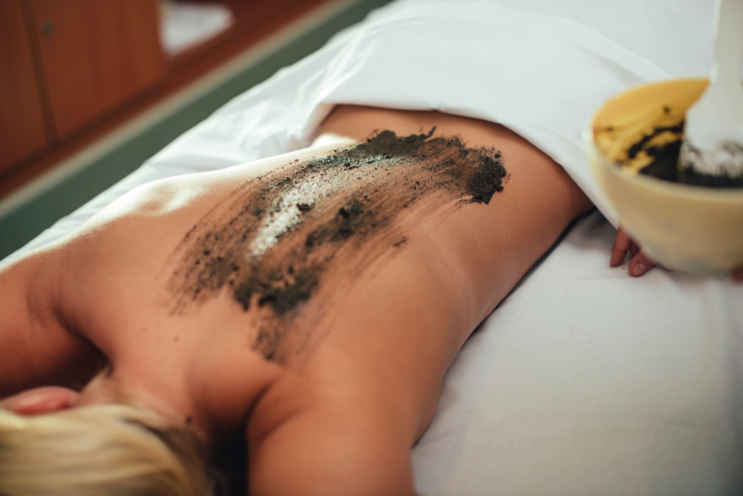 Frau erhält eine Meeresschlickanwendung im Syltness Center