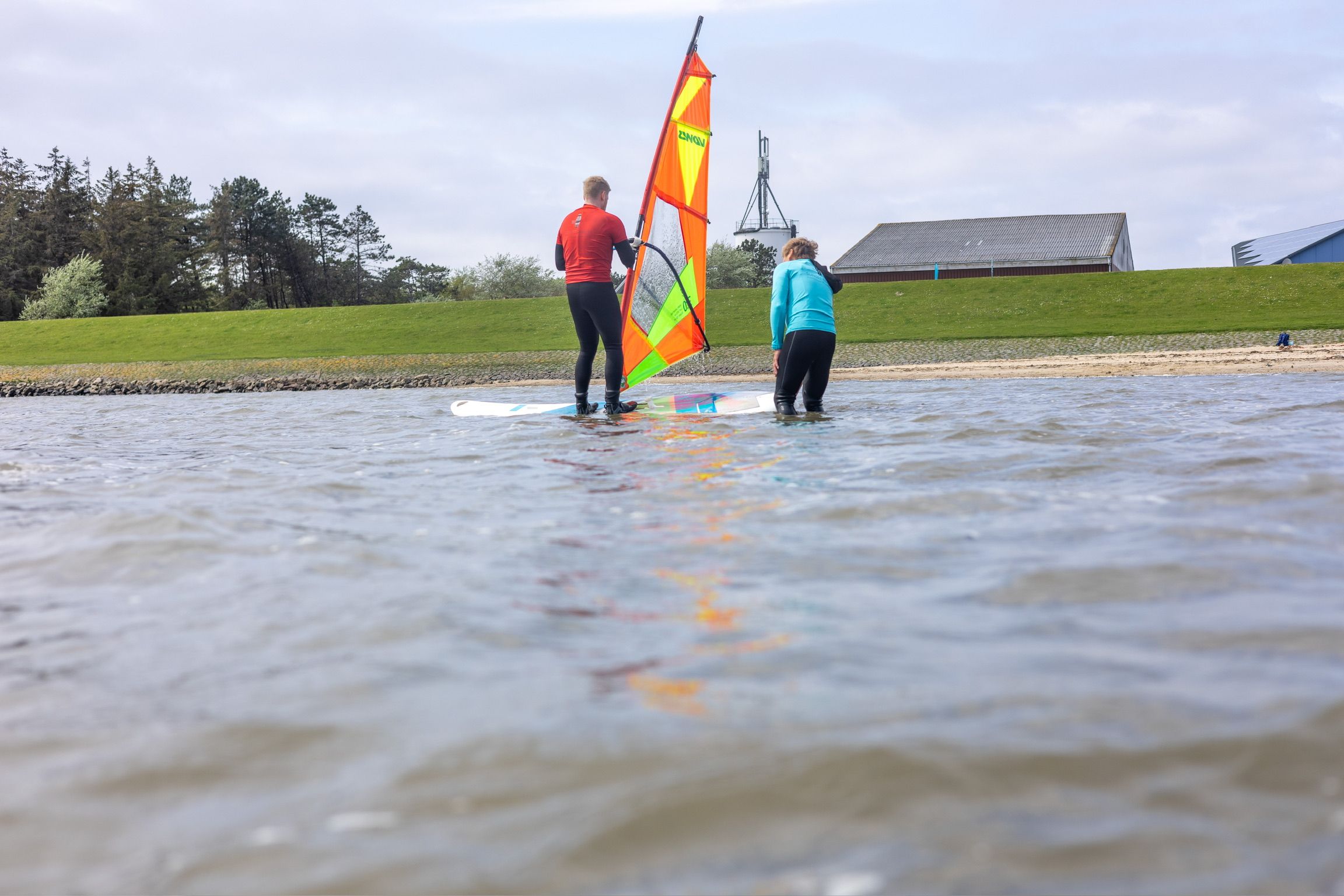 Zwei Menschen, die sich auf's Surfen vorbereiten.