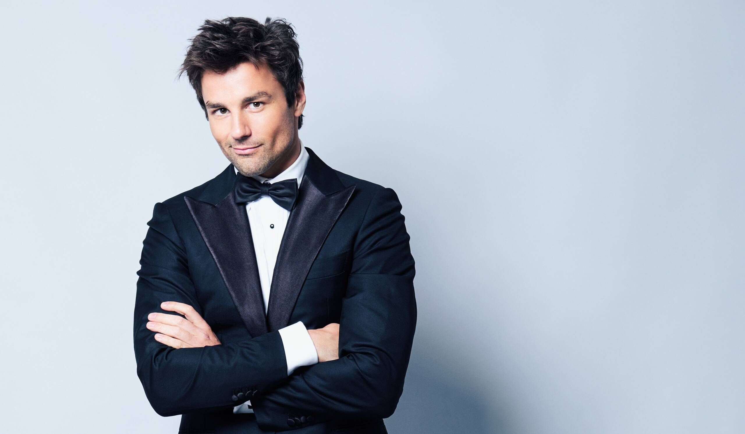 Foto von Lars Redlich im Anzug vor einer weißen Wand