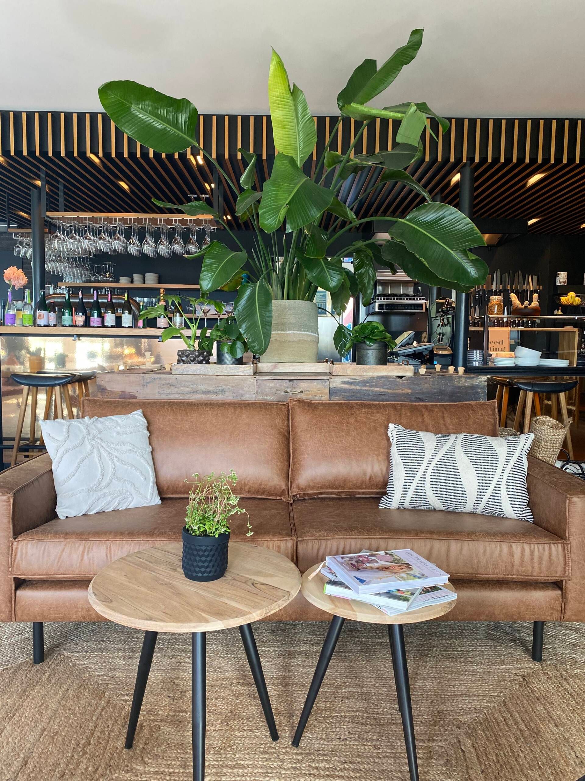 Sitzgelegenheit im Bistro Roots Sylt mit Couch und kleinen Tischen davor platziert.