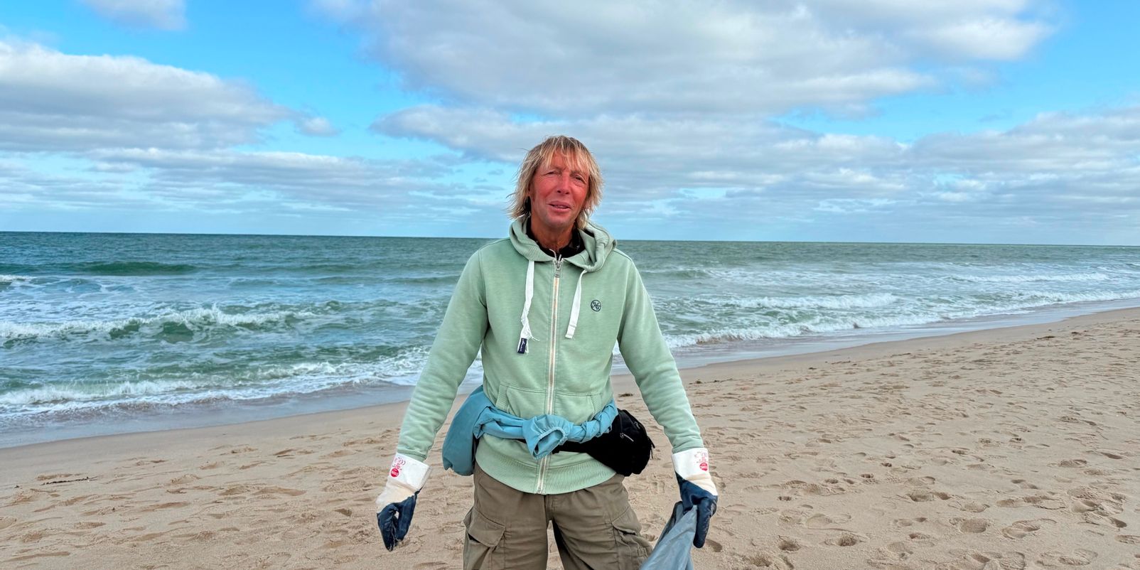 Jürgen sammelt den Müll am Strand.