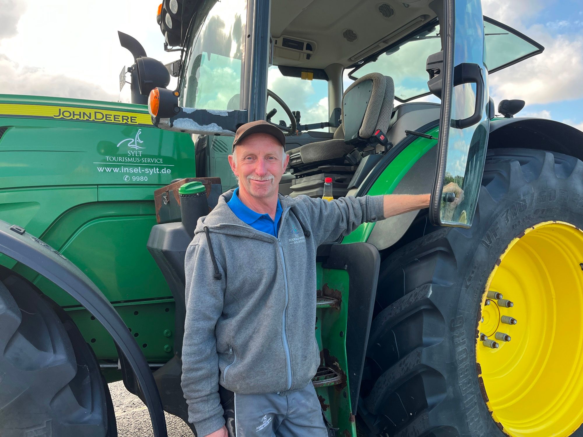 Kraftfahrer Ludolf vom Insel Sylt Tourismus-Service vor dem Traktor