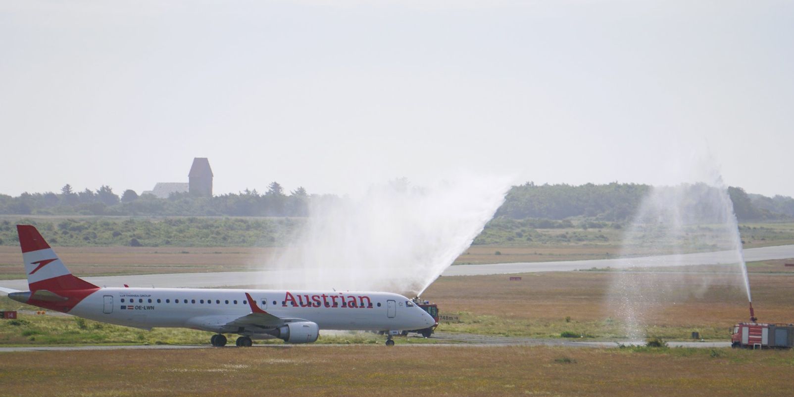 Erstflug Wien-Sylt von Austrian Airlines wird am Flughafen Sylt von der Feuerwehr mit der eine Wasserfontäne empfangen