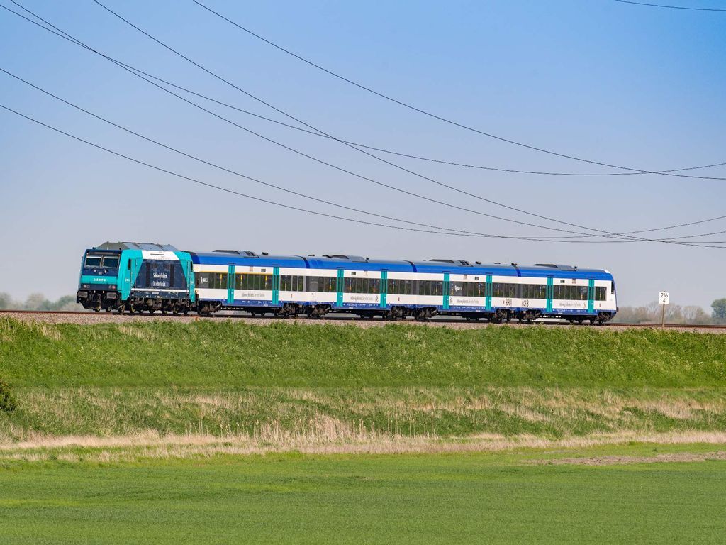 blau-weißer Nahverkehrszug der DB Regio auf dem Bahndamm nach Sylt