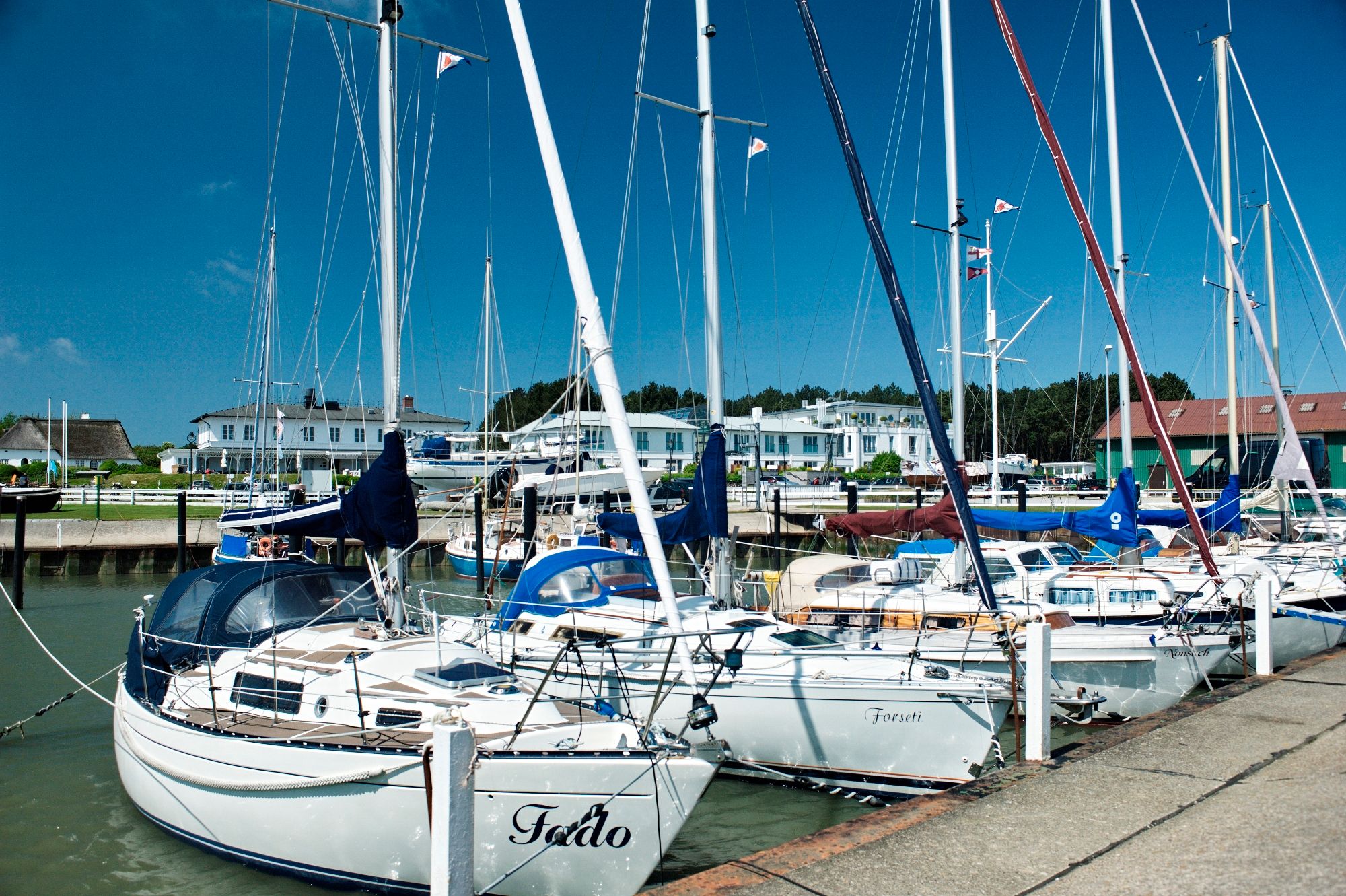 Segelboote im Hafen von Munkmarsch auf Sylt, im Hintergrund ist das Fährhaus Sylt zu sehen