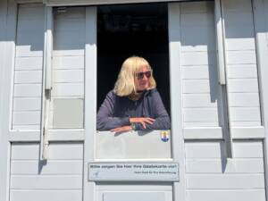 Übergangskontrolleurin Astrid blickt aus ihrem Häuschen am Brandenburger Strand
