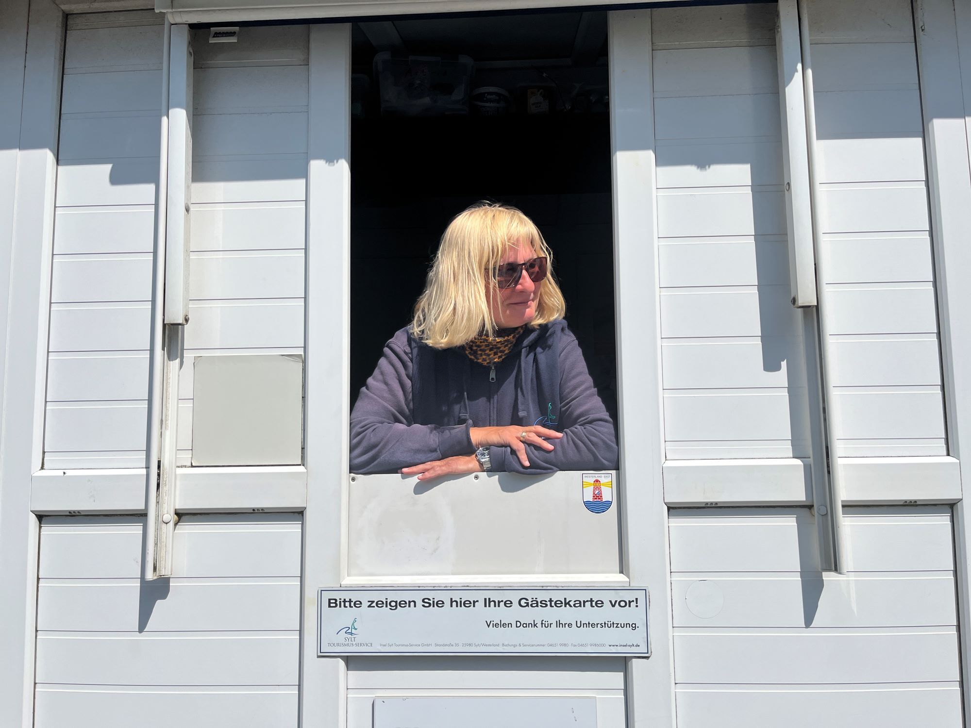 Übergangskontrolleurin Astrid blickt aus ihrem Häuschen am Brandenburger Strand