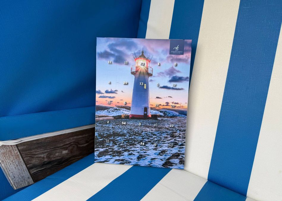 Schokoladen-Adventskalender 2025 des Insel Sylt Tourismus-Service in einem blau-weiß gestreiften Strandkorb platziert