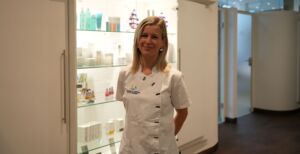 Kosmetikerin Alina Cinsel vor einer Vitrine