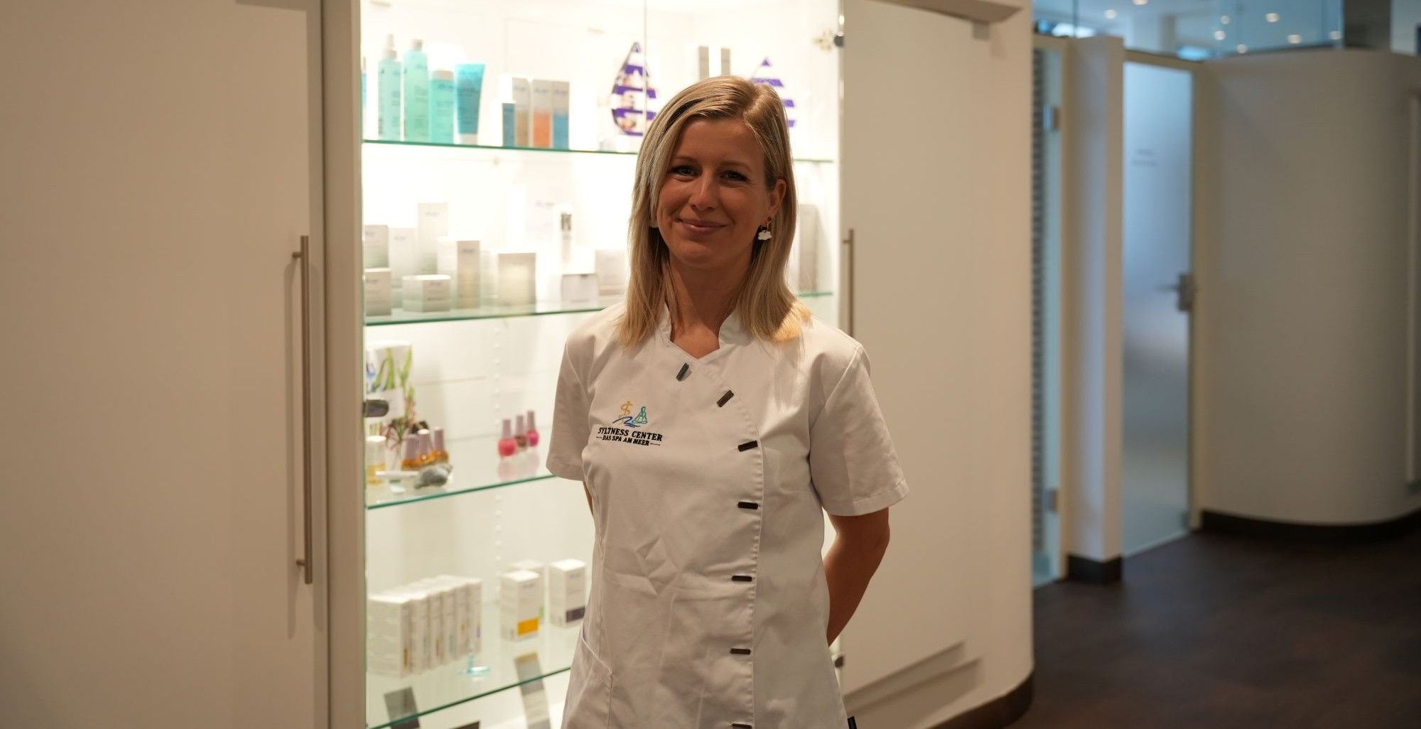 Kosmetikerin Alina vor einer Vitrine