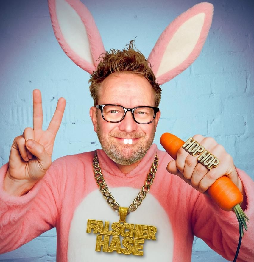Martin Sierp im rosafarbenem Hasenkostüm mit Möhre in der Hand und 
