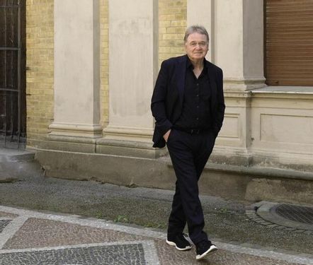 Klaus Hoffmann in schwarzem Anzug vor einem alten Gebäude