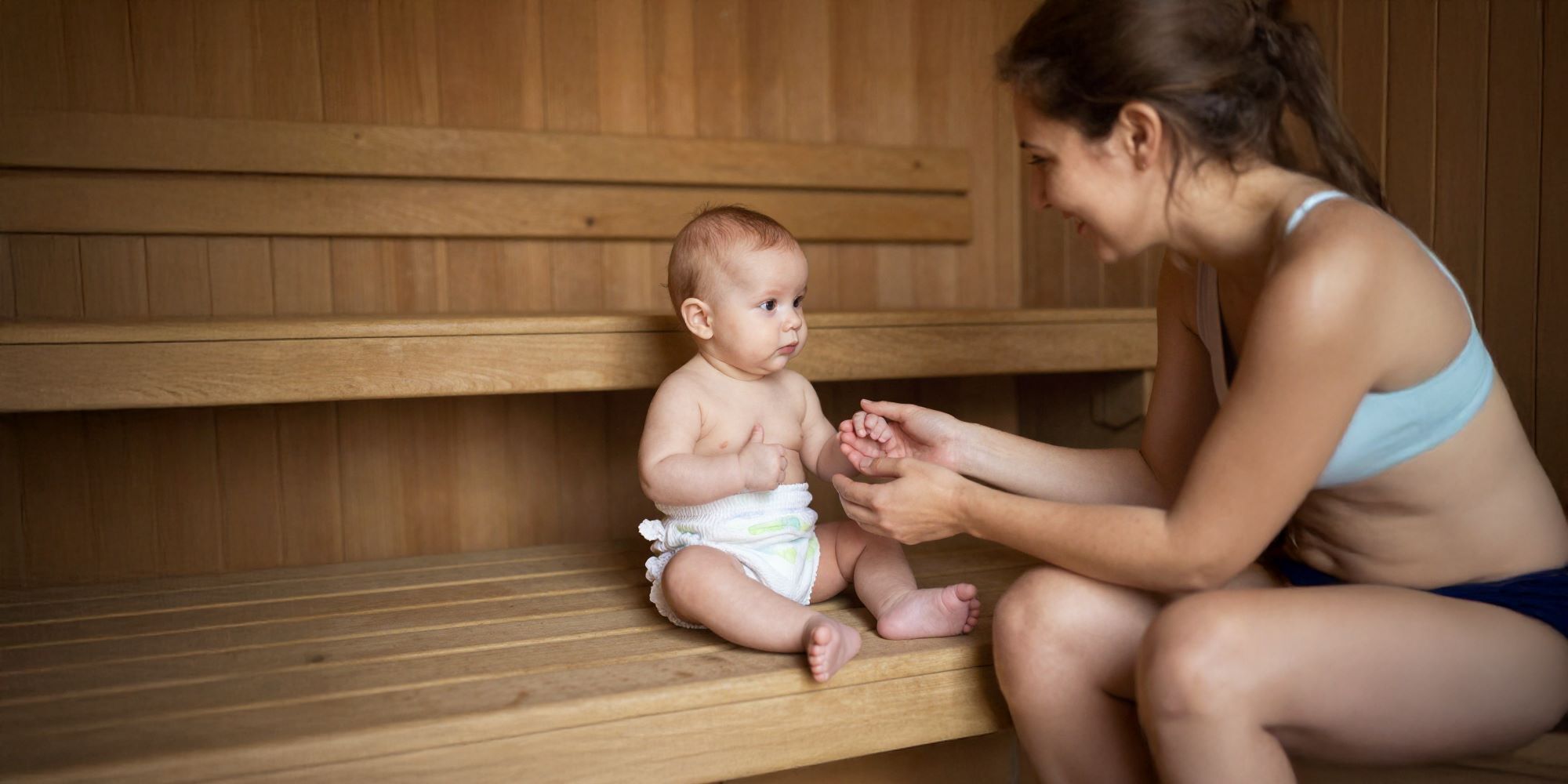 Baby sitzt mit Frau entspannt in der Baby-Sauna in der Sylter Welle