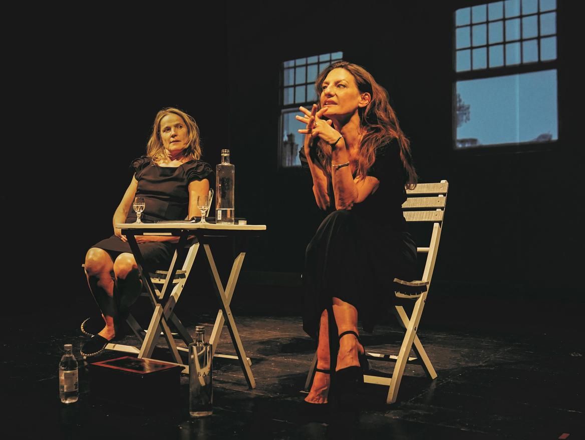 Catrin Striebeck und Karoline Eichhorn sitzen an einem Bistrotisch und halten