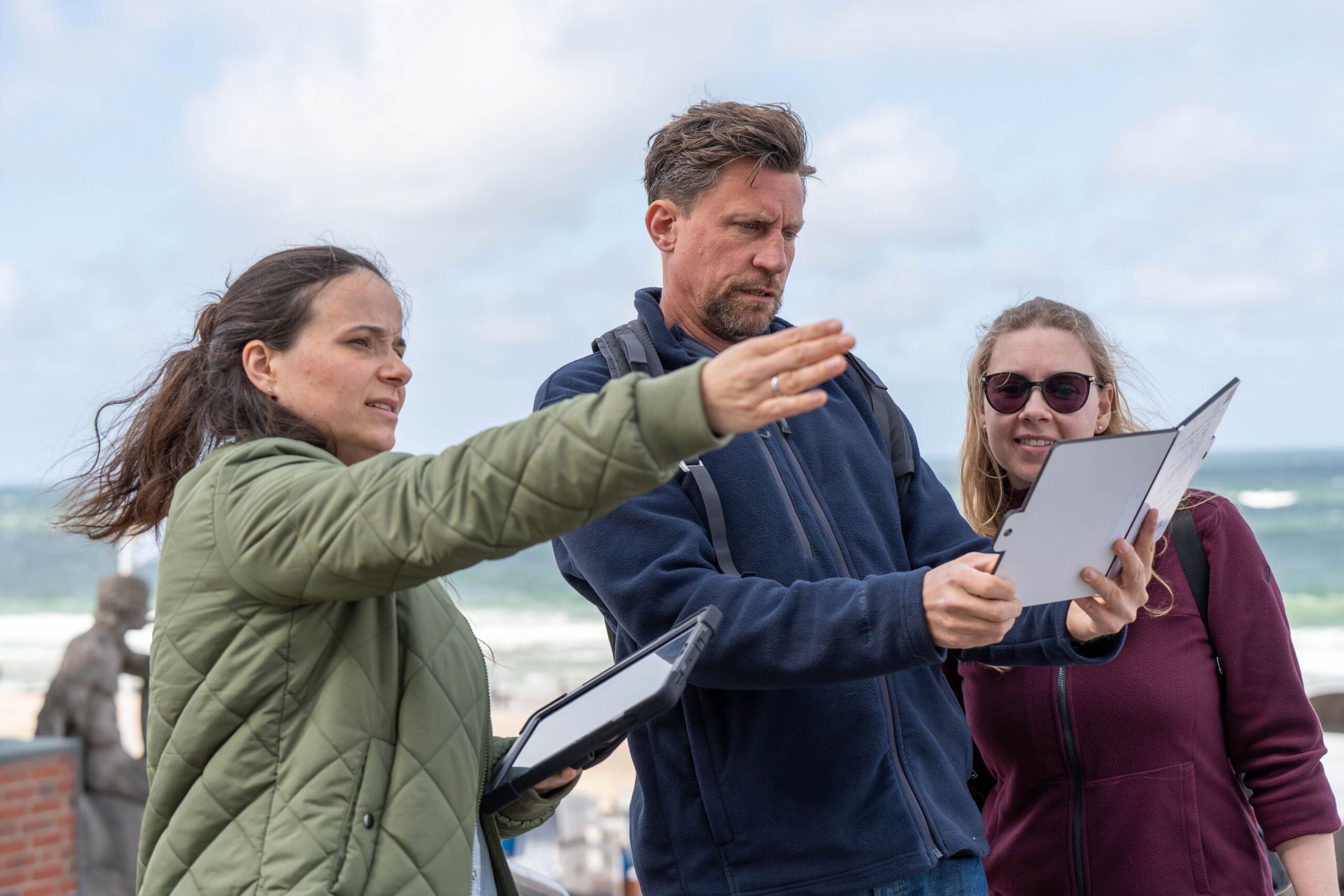 Zwei Frauen und ein Mann lösen eins der Rätsel während der digitalen Outdoor-rRallye in Westerland