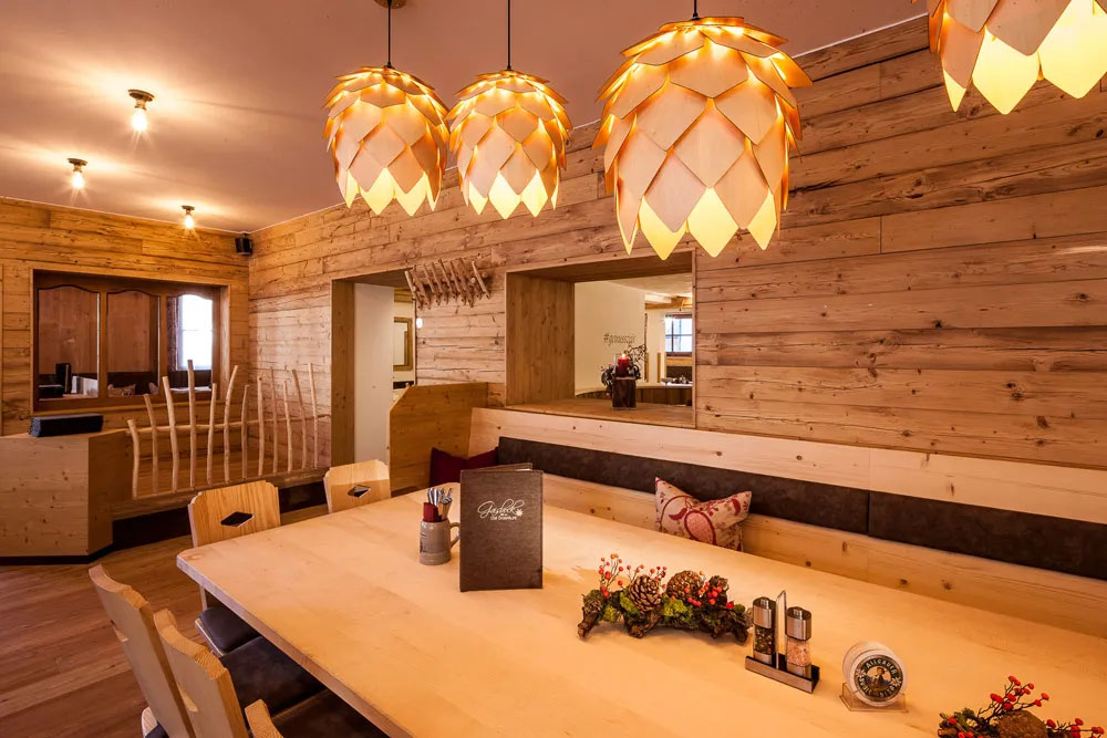 Stilvoller Restaurantbereich mit viel hellem Holz, warmen Licht und wohnlicher Atmosphäre