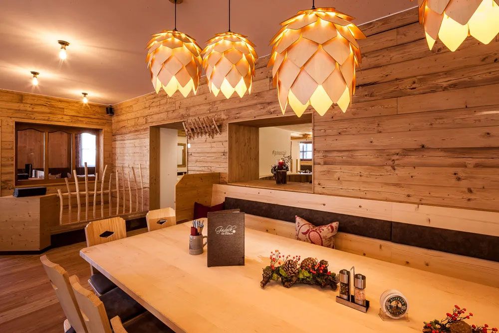 Stilvoller Restaurantbereich mit viel hellem Holz, warmen Licht und wohnlicher Atmosphäre